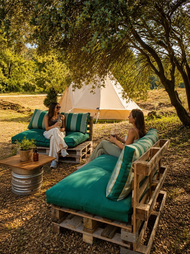 Zona chill del complejo con tiendas de glamping al fondo
